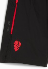 Pantaloni corti neri realizzati in tessuto leggero, con dettagli rossi e un logo laterale che raffigura un leone con fiamme. Include il marchio "PUMATECH".