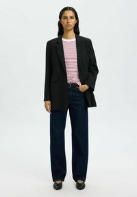 Black blazer over a red and white striped shirt, paired with dark blue wide-leg jeans and black pointed flats. Simple design, tailored fit.