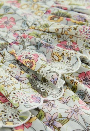 Material textil cu imprimeu floral în nuanțe pastelate, cu margini ondulate și accente de dantelă brodată. Prezintă diverse modele de flori pe un fundal deschis.