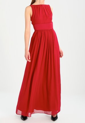 Sleeveless red floor-length gown with gathered bodice and wide waistband, worn with black pointed-toe shoes on a white background.