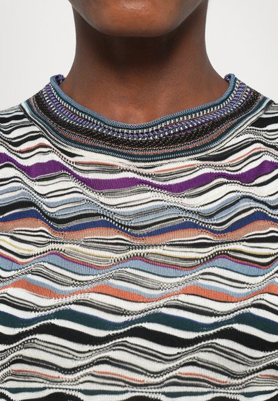 Flerfärgad stickad topp med ett vågmönster, i svart, vitt, lila och blåstrimmor; ribbad krage med dekorativ sömnad.