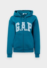 Teal zip-up hoodie with white "GAP" logo on the front. Features a adjustable drawstring hood and front pockets. Soft cotton blend fabric.