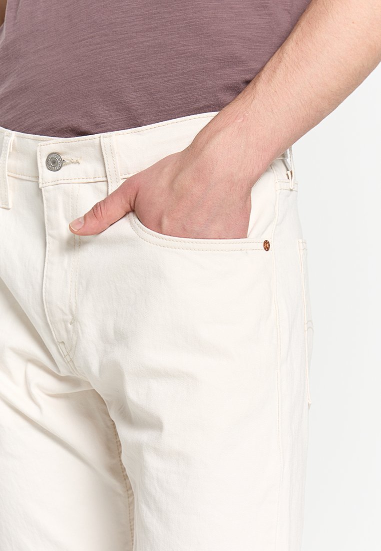 Cremfarbene Baumwollhosen mit geradem Schnitt. Verfügt über eine Fronttasche, einen Metallknopfverschluss und minimale Nahtdetails.