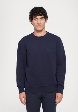 Sweatshirt bleumarin cu guler rotund, mâneci lungi, manșete și tiv cu textură côtelată. Prezintă o grafică subtilă cu un zâmbet pe piept. Textură moale.