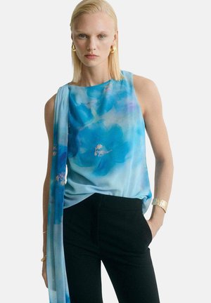 Camisole à imprimé floral dans des tons de bleu avec un détail de foulard fluide, assortie à un pantalon noir. Tissu lisse avec une coupe décontractée.