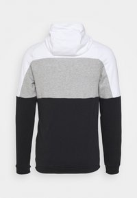 Sweat à capuche avec un design en blocs de couleurs : partie supérieure blanche, section grise au milieu et partie inférieure noire. Confectionné en tissu doux et texturé avec des manches longues.