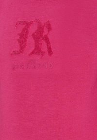 Jasnoróżowa koszulka z wytłoczonym logo "JK" w ciemnoróżowym kolorze oraz napisem "JOHN RICHMOND" poniżej. Wykonana z miękkiej bawełny.