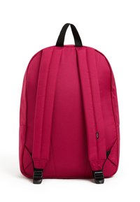 Reppu kirkkaan vaaleanpunaisesta kankaasta, jossa on pehmustetut olkahihnat, ylhäällä kantokahva ja mustat yksityiskohdat. Sileä pinta ja muotoiltu rakenne.