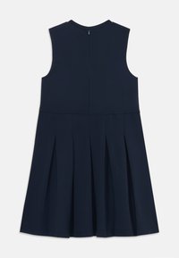 Marineblaues ärmelloses Kleid mit Rundhalsausschnitt, ausgestattet mit einem gefältelten Rock und einem Reißverschluss auf der Rückseite. Hergestellt aus weichem, glattem Stoff.