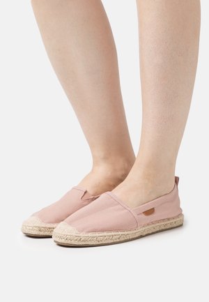 Espadrilles en toile rose clair avec des panneaux élastiques sur les côtés, des détails en corde de jute et une semelle en caoutchouc plate. Aucune marque visible à l'extérieur.
