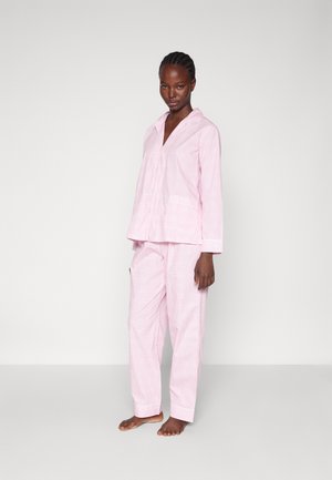 Ljusrosa pajamaset med skjorta med knappar och krage samt matchande byxor. Tyget har ett subtilt rutsystem och har en mjuk textur.