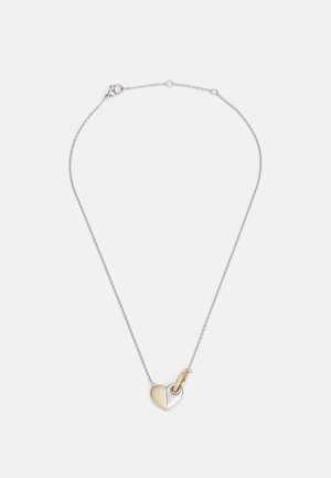 Zilveren ketting met een gesplitst hart hangertje; de ene kant gepolijst goud, de andere kant gepolijst zilver, met een kleine sluiting en accentdetails.
