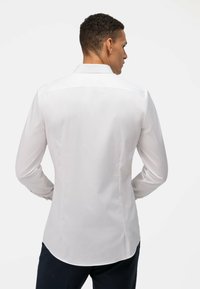 Witte lange mouwen shirt met een standaard kraag, gladde textuur en afgeronde zoom; fitted ontwerp met rugplooien; geen zichtbare patronen of hardware.