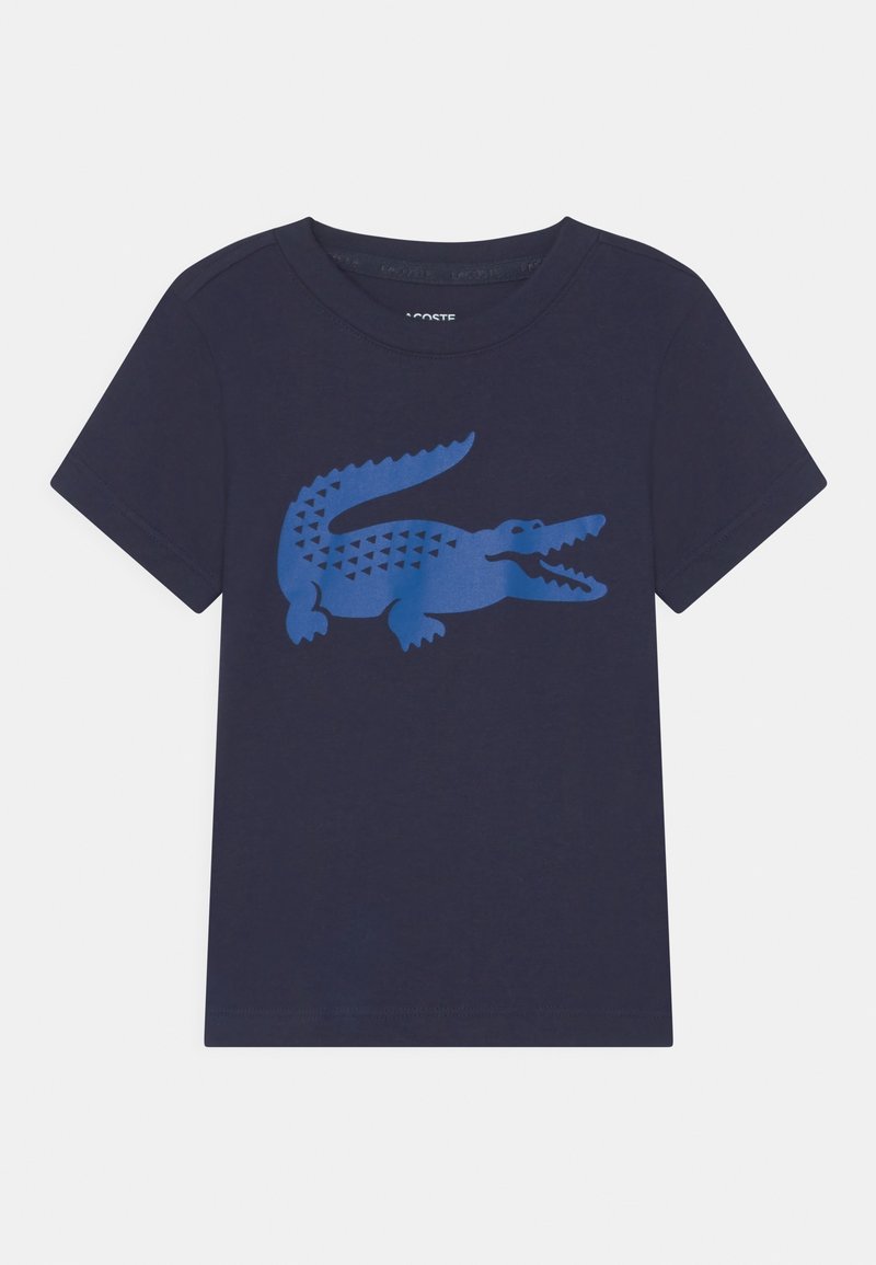 T-shirt bleu marine manches courtes avec un grand motif crocodile bleu à l'avant et un col rond.