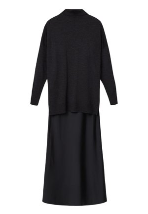 Musta pitkähihaista neulepuseroa yhdistettynä mustaan satiiniin maxi-hameeseen, kuvattuna takaa valkoisella taustalla.