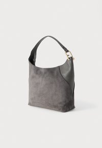 Geantă de mână din piele întoarsă gri și piele, cu o singură curea scurtă și detaliu cu cataramă aurie, expusă pe un fundal alb simplu.