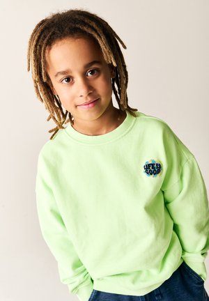 Lys grøn sweatshirt lavet af blødt stof med teksten "LIFE IS GOOD" i blå og sorte nuancer. Behagelig pasform med ribbede manchetter.