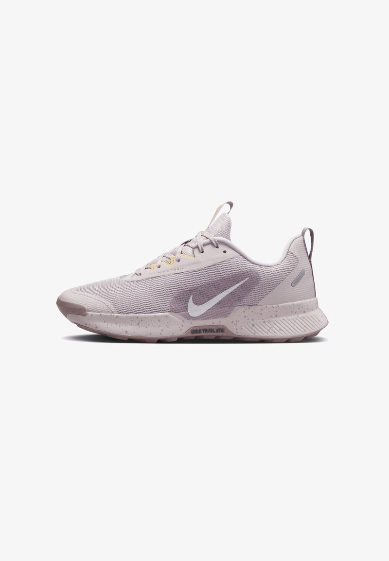 Sapatilha de corrida Nike com um cabedal em malha roxa clara, detalhes contrastantes mais escuros, uma entressola com padrões salpicados e uma sola texturizada para melhor tração.