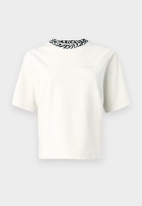 Trumpomis rankovėmis marškinėliai iš smėlio spalvos medvilnės su juodu ir baltu zebro rašto apykaklės detaliu. Minimalistinis dizainas, lengva tekstūra.