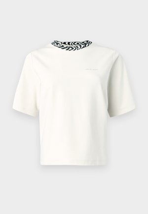 Tricou cu mâneci scurte din bumbac bej deschis, cu detaliu la guler în model zebra alb-negru. Design minimalist, textură ușoară.