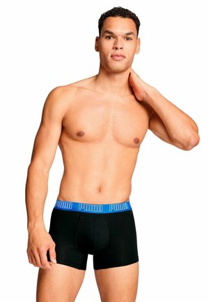 Boxer shorts noirs avec une ceinture bleue au logo PUMA, fabriqués à partir d'un tissu lisse et extensible. Présentent un design ajusté et des coutures minimales.
