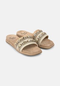 Sandali beige con due ampie cinghie decorate con dettagli metallici e intrecciati. Sottopiede in morbido camoscio, design open-toe, suola piatta.