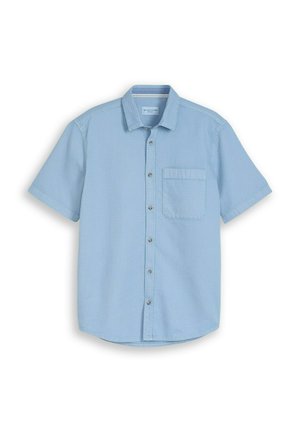 Chemise à manches courtes bleu clair avec tissu texturé et une poche poitrine unique, affichée à plat sur un fond blanc.