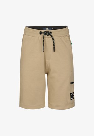 Sort grafisk t-shirt med grøn tekst og mønster, beige cargobukser, hvide sneakers og stribede sokker. Barn står med hænderne ned langs siderne.