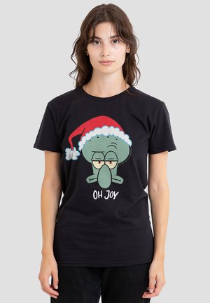 Schwarzes T-Shirt mit kurzen Ärmeln, das ein Grafikdesign eines grünen Charakters mit einer Weihnachtsmütze und dem Text "OH FREUDE" darunter zeigt.