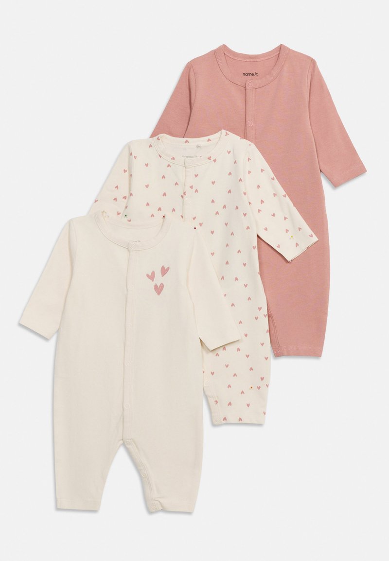 Drie babyrompers met lange mouwen in roze, crème met roze hartjes en crème met drie grotere roze hartjes op de borst, vooraan drukknoopsluiting.