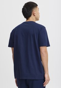 Marineblå bomulds t-shirt med rund hals og korte ærmer. Glat tekstur, enkelt design, lige snit, og ingen synlige mønstre eller detaljer.