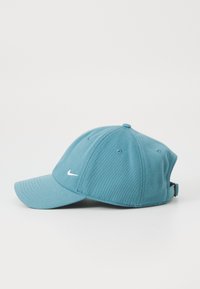 Casquette de baseball teal en coton, avec une visière courbée, un design à six panneaux et un petit logo Nike blanc à l'avant. Sangle arrière ajustable.