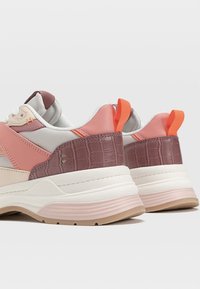 Baskets avec un mélange de matériaux : accents rose pâle, bordeaux et corail ; motif croco texturé sur le talon ; semelle rembourrée ; languette de traction à l'arrière.