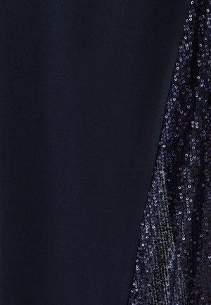 Tissu bleu marine avec une texture lisse sur une face et un accent à sequins sur l'autre, ajoutant de la brillance et du contraste visuel.