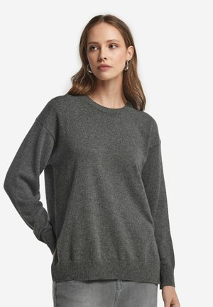 Pull gris en tissu tricoté doux, avec un col rond, un design à épaule tombante et des bordures côtelées aux poignets et à l'ourlet. Simple et polyvalent.