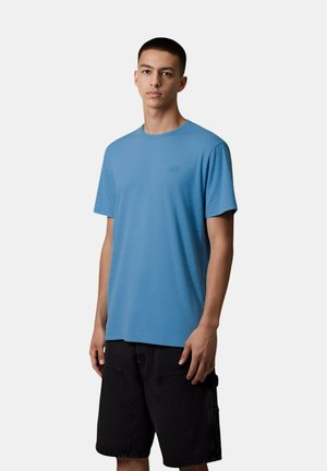 T-shirt blu a maniche corte con scollatura a girocollo, realizzato in tessuto testurizzato, dotato di un piccolo logo sul petto, abbinato a pantaloni corti neri.