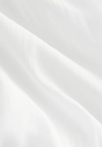 Tela blanca con una textura suave y lisa que muestra pliegues delicados y un brillo sutil, destacando su naturaleza ligera y fluida.