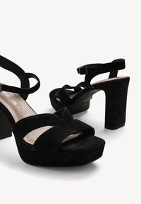 Sandalias de tacón alto de ante negro con plataforma, con tiras cruzadas y hebilla en el tobillo. Diseño de tacón cuadrado para mayor estabilidad.