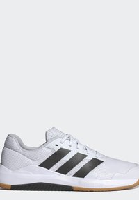 Chaussure de sport blanche avec bandes Adidas noires, tige en mesh, lacets blancs et semelle en gomme et caoutchouc noir.