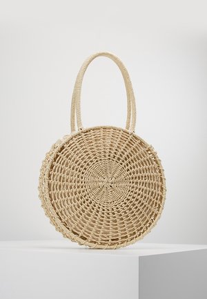 Bolso redondo de paja tejido con dos asas resistentes, patrón circular intrincado y un forro interior de tela suave.