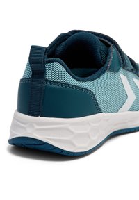 Blauwe en turquoise sportieve schoen met een bovenwerk van mesh, verstevigde hiel, witte accenten en een zool met een hexagonaal patroon voor grip.