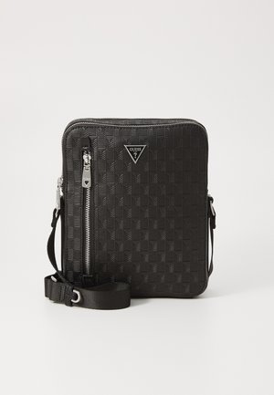 Schwarze Umhängetasche mit geometrischem Prägungsmuster, silberner Hardware, Reißverschlussverschluss, verstellbarem Riemen und markantem Logoschmuck.