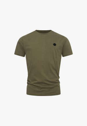 T-shirt in cotone verde oliva con scollo rotondo, maniche corte e una toppa circolare nera sul lato sinistro del petto.