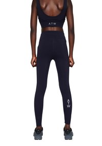Marineblauwe sportleggings met een hoge tailleband, voorzien van zijzakken en de letters "ATW" gedrukt op het onderbeen. Soepele, rekbare stof.