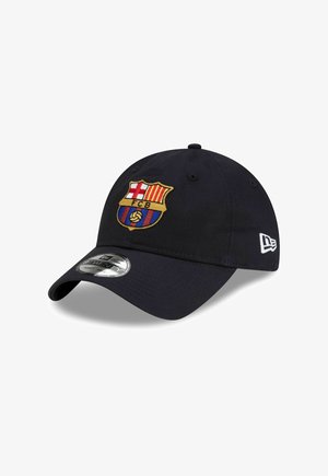 Gorra de béisbol azul marino con un logo bordado del FC Barcelona, que presenta franjas rojas y amarillas, una visera curva y un clip de ajuste plateado.