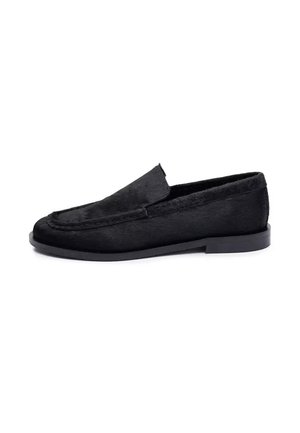 Zwarte slip-on loafer met lage hak en gestikte details, gemaakt van textuurmateriaal, zijaanzicht op een witte achtergrond.
