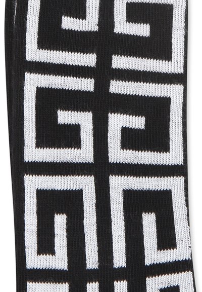 Calzini neri con un motivo geometrico bianco caratterizzato da forme interconnesse. Realizzati in un tessuto a maglia con una texture liscia.