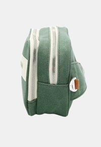 Pochette en toile verte avec deux zips argentés, accents crème, poche latérale et un onglet en cuir marron. Forme rectangulaire, texture robuste.