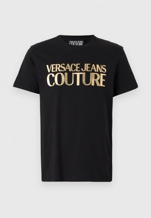 Črna bombažna majica s kratkimi rokavi, ki se ponaša z velikim zlatim napisom 'VERSACE JEANS COUTURE'. Okrogla izreza. Preprost dizajn.