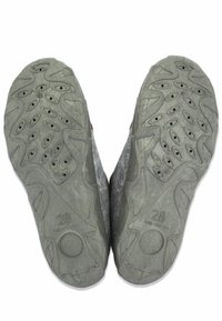 Semelles de chaussures en caoutchouc grises avec des motifs texturés et des grips circulaires, portant le numéro "28" embossé sur le dessous.